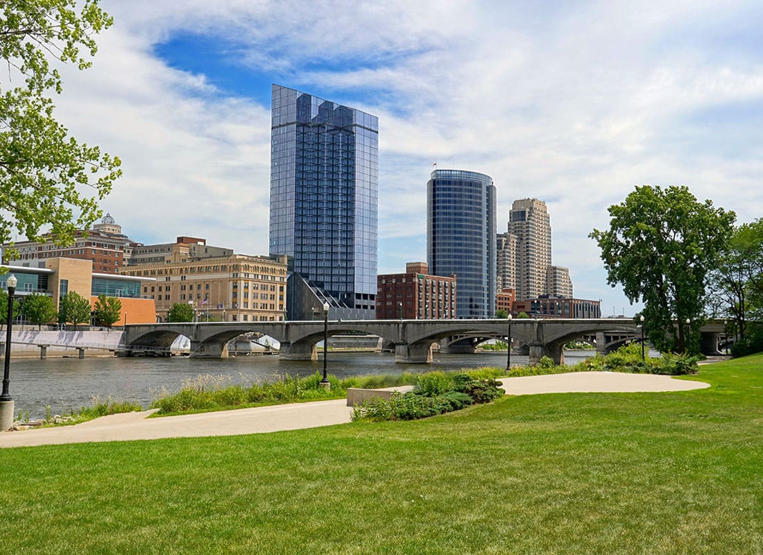 Contact - View of Commercial Buildings in Downtown Grand Rapids Michigan from a Park with Green Grass and Trees