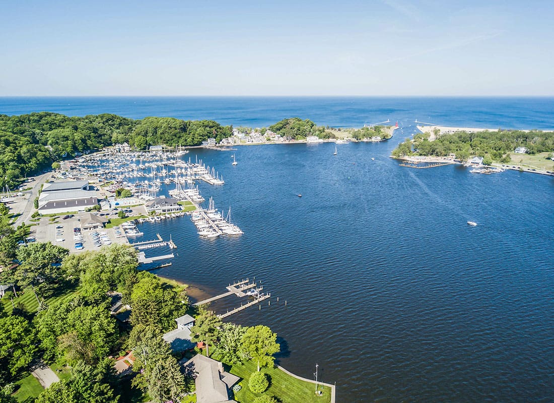 Holland, MI - Aerial View of Boats on a Lake Surrounded by Green Trees in Holland Michigan on a Sunny Day