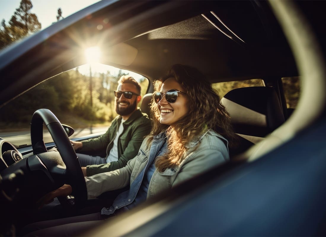 Read Our Reviews - Portrait of a Young Smiling Couple Wearing Sunglasses Sitting in a Car During a Road Trip on a Sunny Day